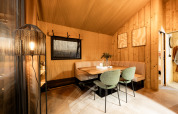 Eethoek in een luxe safaritent met houten wanden en stijlvolle meubels bij Kampeerdorp de Zandstuve.