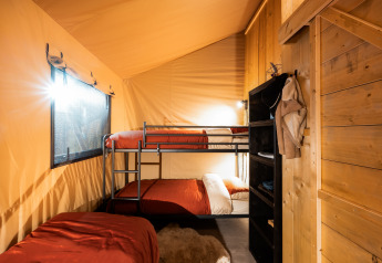 Interior de la tienda safari Avonturenlodge con literas en Kampeerdorp de Zandstuve, Países Bajos.