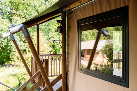 Close-up van safaritent Avonturenlodge bij Kampeerdorp de Zandstuve in Nederland en een houten terras.