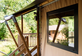 Close-up van safaritent Avonturenlodge bij Kampeerdorp de Zandstuve in Nederland en een houten terras.