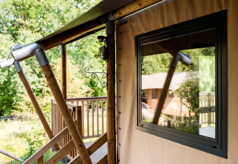 Primer plano de la tienda safari Avonturenlodge en Kampeerdorp de Zandstuve, Países Bajos, con terraza.