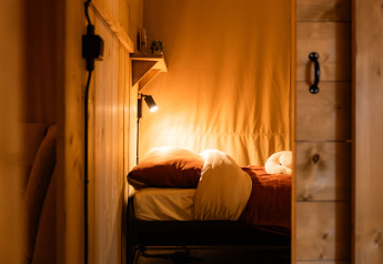 Gemütliches Safari-Zelt Avonturenlodge DeLuxe bei Kampeerdorp de Zandstuve, Niederlande, mit warmem Licht.