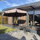 Terrasse am Modus Wellness 2 Lodge in Zuiderzee, Niederlande, mit Tisch, Stühlen und Sonnenschirm.