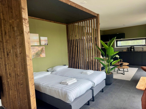 Modernes Lodge-Zimmer Modus Wellness 2 am Zuiderzee in den Niederlanden mit Küche und zwei Betten.
