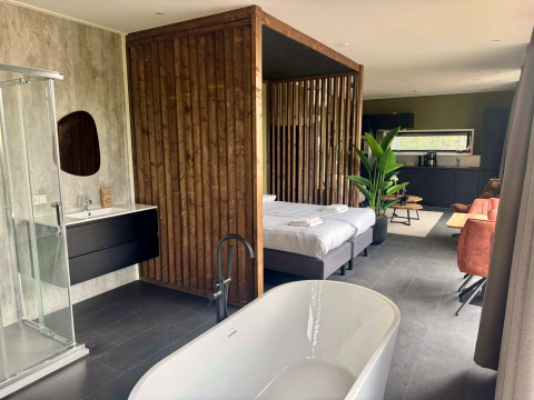 Moderne lodge Modus Wellness 2 ved Zuiderzee, Holland, med badekar, dobbeltseng og stilfuldt interiør.
