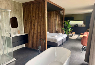 Moderne lodge Modus Wellness 2 ved Zuiderzee, Holland, med badekar, dobbeltseng og stilfuldt interiør.