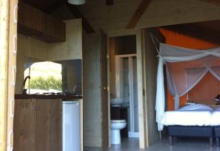 Safaritent met sanitaire voorzieningen, keukentje en bed op Camping Podere sei Poorte in Italië.