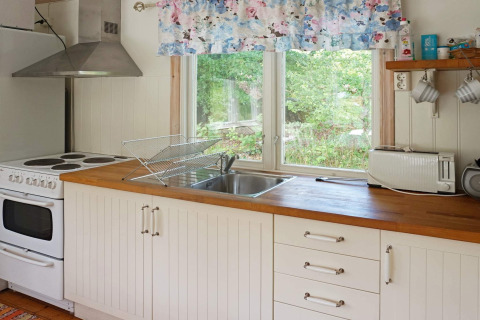 Cucina luminosa e accogliente in una casa vacanza per 4 persone a Smedstorp, Svezia, con piano in legno.