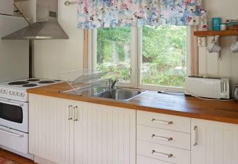 Cuisine lumineuse et accueillante d'une maison de vacances pour 4 personnes à Smedstorp, Suède, plan de travail bois.