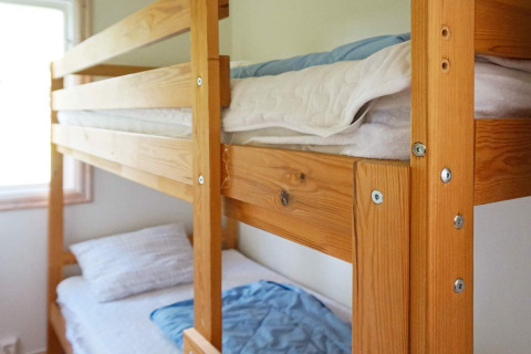 Litera de madera en una habitación luminosa de la casa vacacional para 4 personas en SMEDSTORP, Suecia.