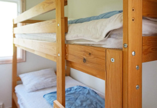 Letto a castello in legno in una camera luminosa della casa vacanza per 4 persone a SMEDSTORP, Svezia.
