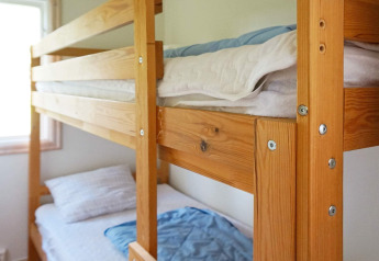 Lit superposé en bois dans une chambre lumineuse du gîte 4 personnes à SMEDSTORP, Suède, draps propres.