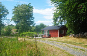 Gemütliches rotes Ferienhaus für 4 Personen in SMEDSTORP, Schweden, umgeben von grüner Natur.