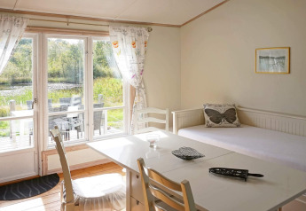 Helles Wohnzimmer im Ferienhaus in Smedstorp, Schweden, mit Zugang zur Terrasse und Seeblick.