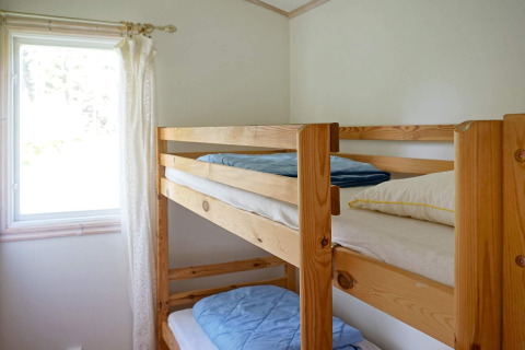 Simple room with wooden bunk beds by a window, 4 person holiday home in Smedstorp, Sweden.
