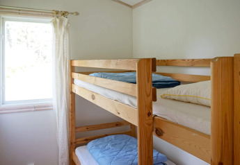 Schlichtes Zimmer mit Etagenbett und Fenster, im 4-Personen-Ferienhaus in Smedstorp, Schweden.