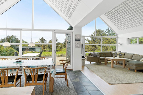 Helles Wohnzimmer im 6-Personen-Ferienhaus in Blokhus, Dänemark, mit Panoramafenstern und Naturblick.