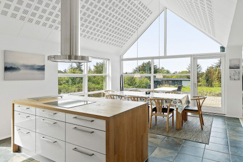 Heldere, moderne keuken en eetruimte met grote ramen en uitzicht op natuur in 6-persoons vakantiehuis Blokhus.