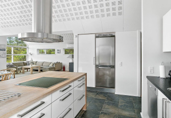 Moderne keuken en woonkamer in een vakantiehuis in Blokhus, Denemarken, met veel lichtinval.