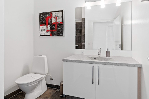Moderne badkamer in een 6-persoons vakantiehuis in Blokhus, Denemarken met kunst en grote spiegel.