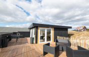 Außenterrasse der Seaside Charm in Rindby, Dänemark, mit modernen Möbeln und Sonnenschein.