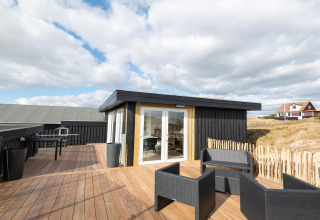 Außenterrasse der Seaside Charm in Rindby, Dänemark, mit modernen Möbeln und Sonnenschein.