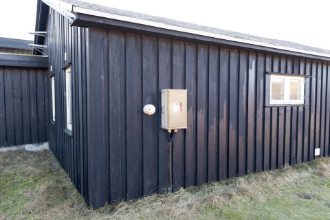 Außenansicht der Seaside Charm in Rindby Lodge in Dänemark mit schwarzen Holzpanelen und Fenster.