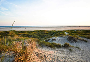 Schönes Foto von Sanddünen und weitem Strand mit Blick auf das Meer, aufgenommen bei einer Lodge.