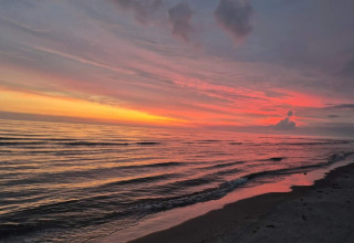 Sonnenuntergang am Meer bei ruhigen Wellen, gesehen am Seaside Charm in Rindby, Dänemark.