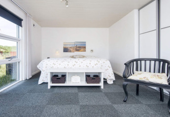 Helles Schlafzimmer in der Lodge 'Seaside Charm in Rindby', Dänemark, mit Doppelbett und Fenster.