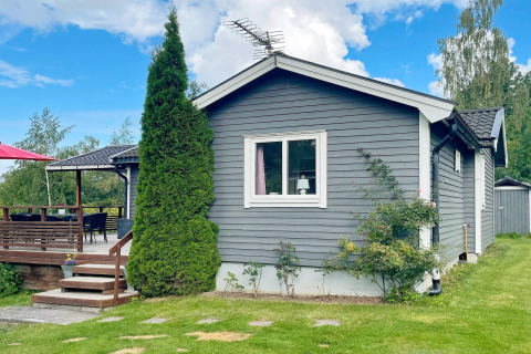 Außenaufnahme eines grauen Ferienhauses für 6 Personen in Gränna, Schweden, mit Terrasse und Garten.