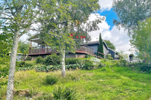 Vakantieverblijf voor zes personen in Gränna, Zweden, met houten terras en omgeven door groen.