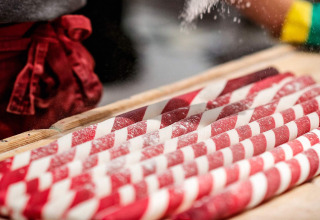 Handgemaakte rood-witte snoepstokken worden bestrooid met suiker in Gränna, Zweden.