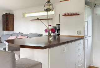 Modernes Ferienhaus in Gränna, Schweden, mit heller Einrichtung, Eckküche und Holzarbeitsplatte.