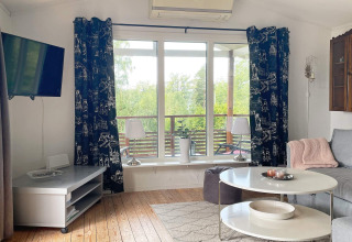 Lichte leefruimte in vakantiehuis te Gränna, Zweden, met grote ramen, moderne meubels en uitzicht.