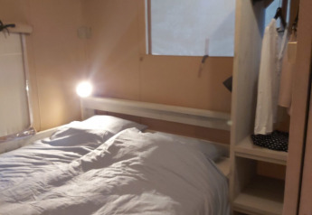 Inside a Ranger Lodge safari tent at Petite Suisse in Belgium, featuring a double bed, closet, and window.