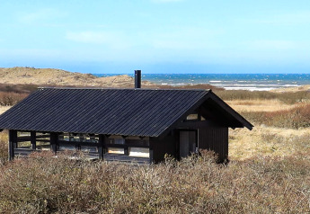 Casa de vacaciones para 4 personas en Bindslev, Dinamarca, con techo negro, dunas y vista al mar.
