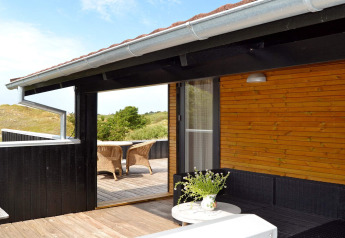 Houten terras met tuinmeubilair bij het 6-persoons vakantiehuis in Fanø, Denemarken, omgeven door natuur.