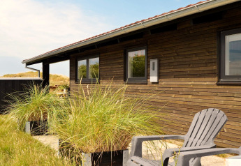 Vue extérieure d'une maison de vacances pour 6 personnes à Fanø, Danemark, avec façade en bois.