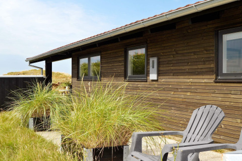 Vista esterna di casa vacanze per 6 persone a Fanø, Danimarca, con rivestimento in legno.