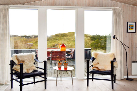 Helles Wohnzimmer im 6-Personen-Ferienhaus auf Fanø, Dänemark, mit Panoramafenstern und gemütlichen Sesseln.
