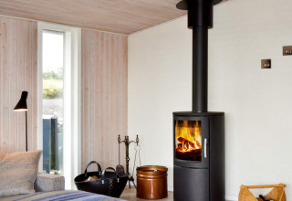 Wohnzimmer im 6-Personen-Ferienhaus auf Fanø, Dänemark, mit Kaminofen und moderner Einrichtung.