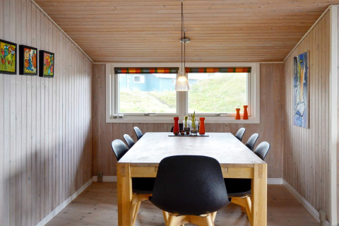 Essbereich im Ferienhaus für 6 Personen auf Fanø, Dänemark, mit Holzdecke, Bildern und modernen Stühlen.