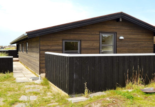 Außenansicht eines 6-Personen-Ferienhauses in Fanø, Dänemark, mit schwarzer Holzfassade.