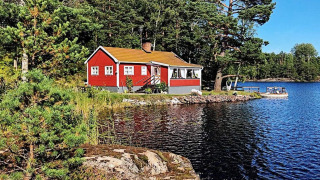 Gemütliches rotes Ferienhaus am See in ÅKERSBERGA, umgeben von Wald und Natur, ideal zum Entspannen.