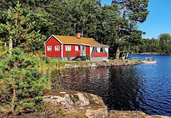 Gemütliches rotes Ferienhaus am See in ÅKERSBERGA, umgeben von Wald und Natur, ideal zum Entspannen.