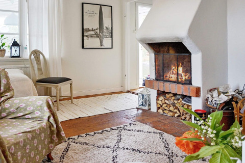 Gemütliches Wohnzimmer im 5-Personen-Ferienhaus in Åkersberga, Schweden, mit Kamin und Pflanze.