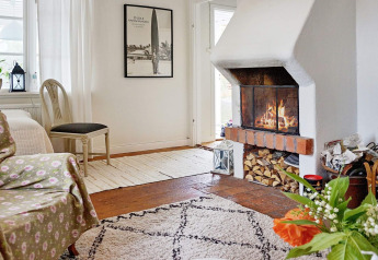 Gemütliches Wohnzimmer im 5-Personen-Ferienhaus in Åkersberga, Schweden, mit Kamin und Pflanze.