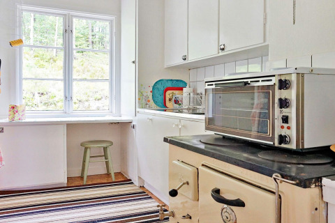Cucina luminosa con finestra, forno e piano cottura in una casa vacanze per 5 persone ad Åkersberga, Svezia.