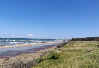 Beachfront view from 4 person holiday home in Bindslev, Denmark, with dunes, sea waves, and blue sky.
